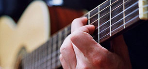 Guitarunderviser spiller akkorder og noder på guitar